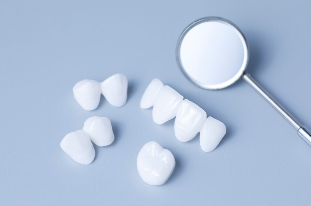 Zahnarztspiegel und Zahnersatz auf einem hellblauen Hintergrund
